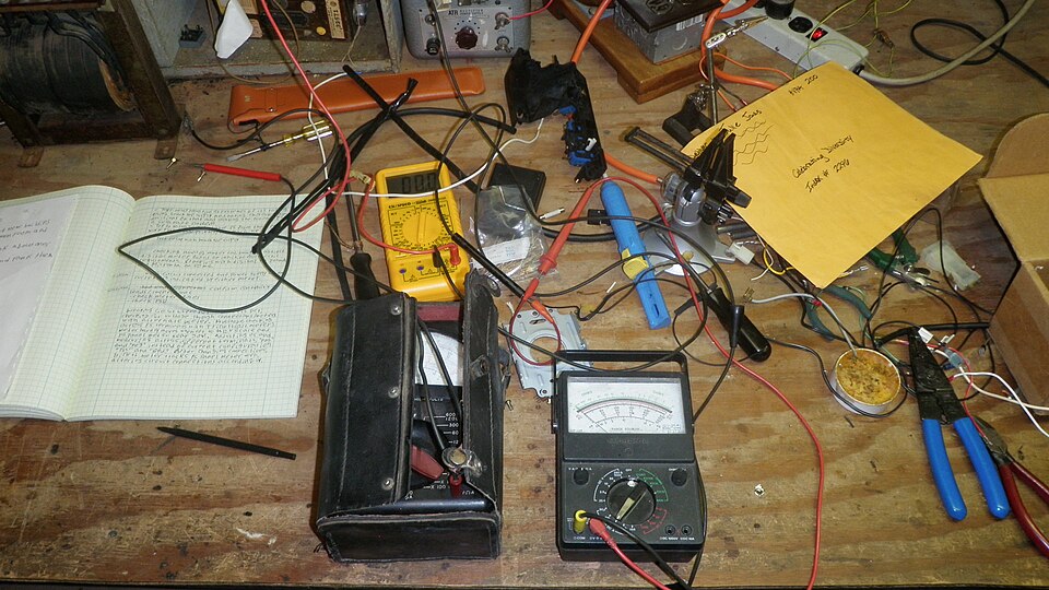 Analog and digital multimeters connected for electrical testing